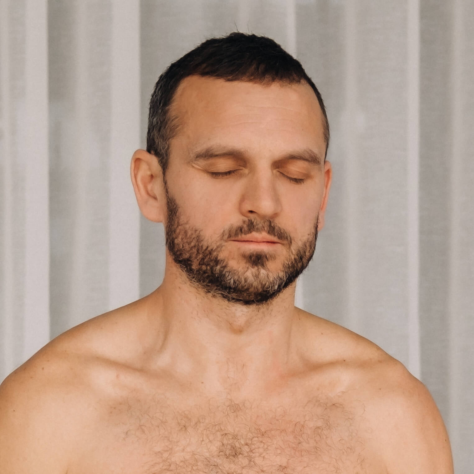 a man with a bare torso does yoga in a fitness roo H8B5GNK Home